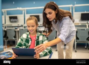 enseignant utilisant tablette avec eleves attentifs